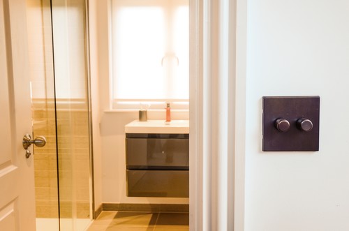 Bronze dimmer switch outside bathroom