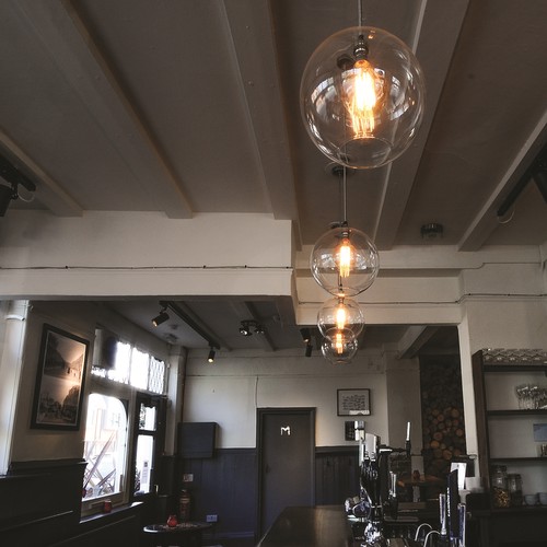 Glass globe pendants over bar area