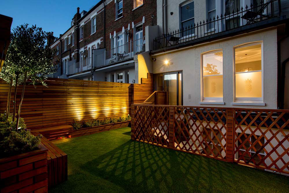 LED Hood spike lights in a timber-fenced garden