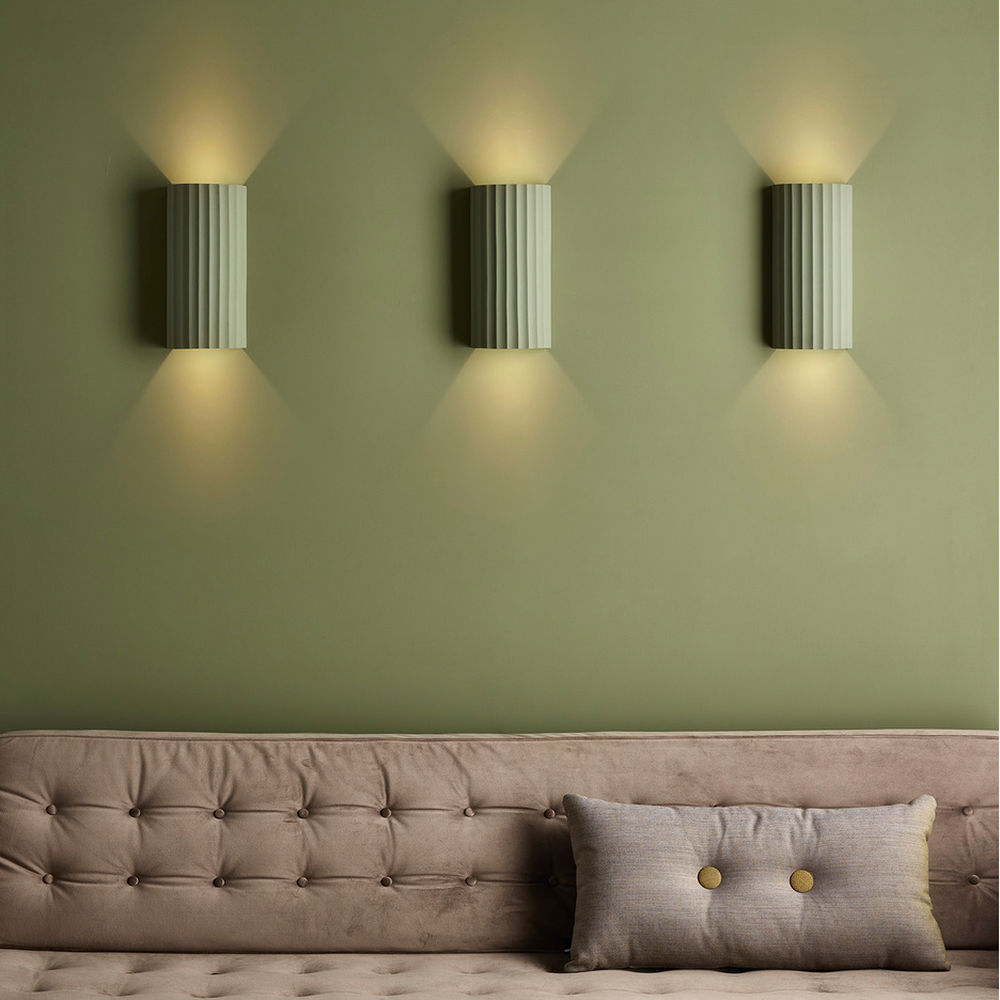 Astro Kymi wall lights on a sage green living room wall